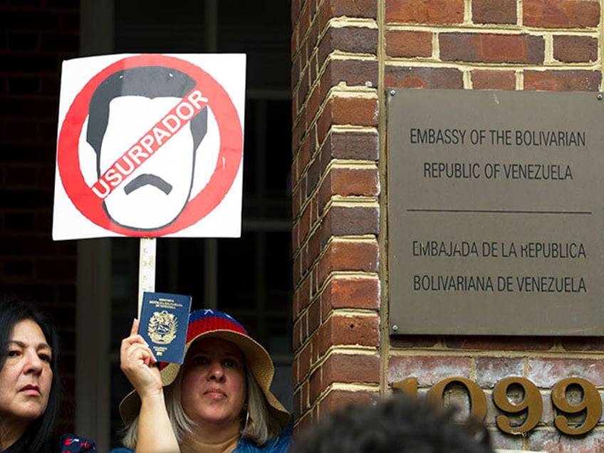 Demonstrators holds up their Venezuelan passport outside the Venezuelan embassy in Washing