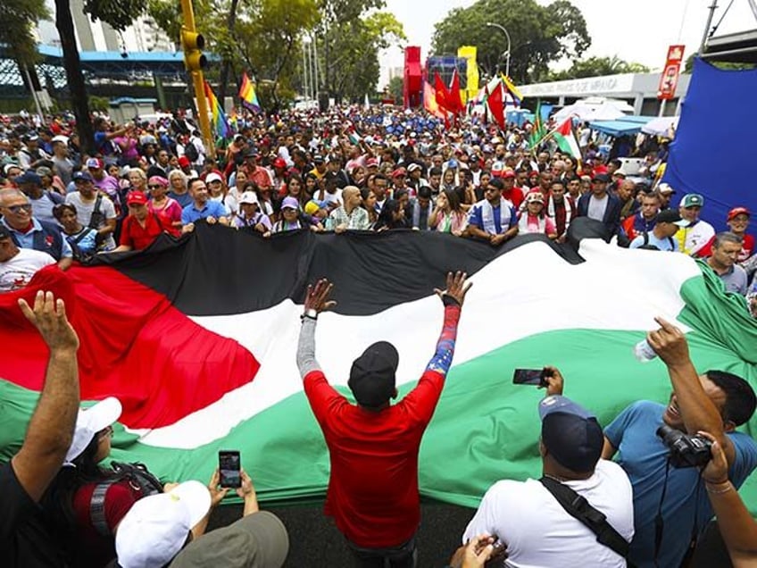 Demonstrators unfurl Palestinian flag as supporters of Chavismo march to the headquarters