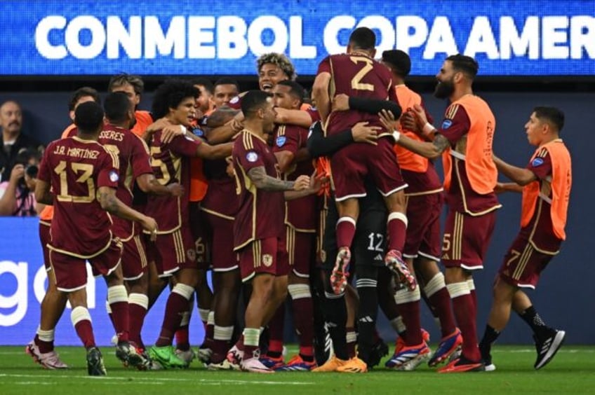 Venezuela's players mob goalscorer Salomon Rondon after his decisive penalty in the 1-0 wi