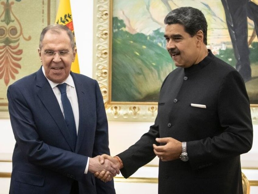 Nicolas Maduro, Venezuela's president, right, shakes hands with Sergei Lavrov, Russia