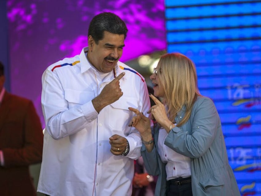 Venezuela's President Nicolas Maduro dances next to his wife, Cilia Flores, during a pro-government demonstration in Caracas, Venezuela, Tuesday, Feb. 12, 2019. Nearly three weeks after the Trump administration backed an all-out effort to force out Venezuelan President Nicolas Maduro, the embattled socialist leader is holding strong and defying predictions of an imminent demise. (AP Photo/Rodrigo Abd)