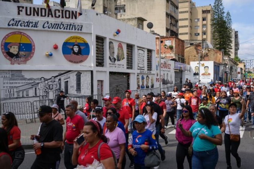 Supporters of President Nicolas Maduro walk past the headquarters of the 'Catedral Combati