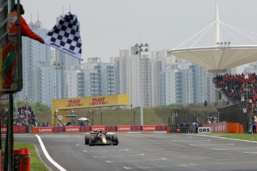 Red Bull Racing's Dutch driver Max Verstappen takes the chequered flag in Shanghai