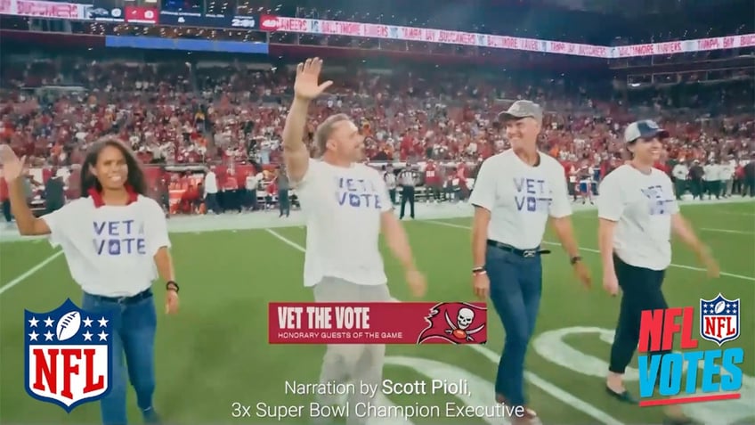 Vet the Vote volunteers wave to crowd at NFL game