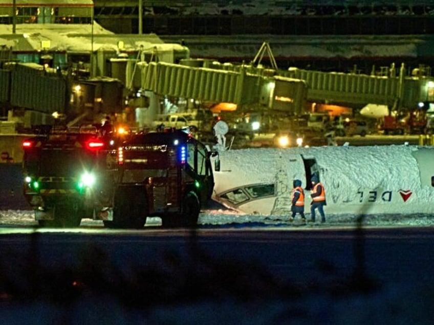 A Delta airlines plane sits on its roof after crashing upon landing at Toronto Pearson Air