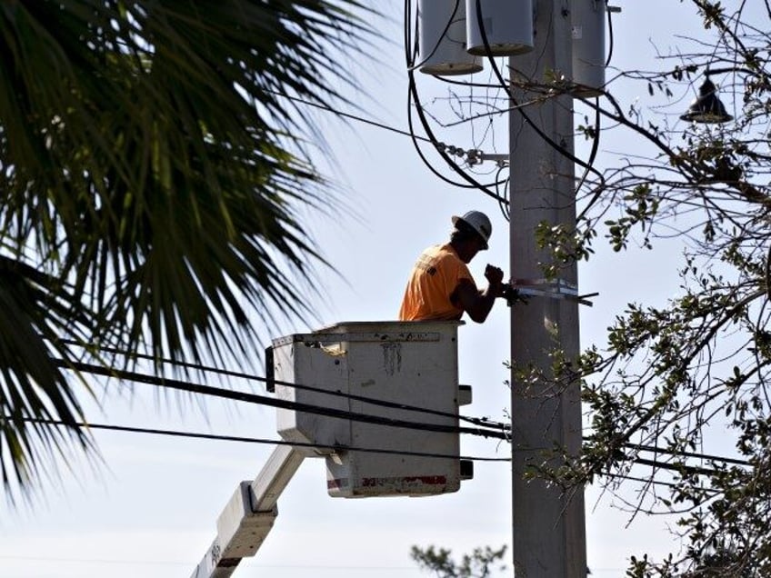 A lineman works on a utility pole as electricity is restored after Hurricane Irma in Fort