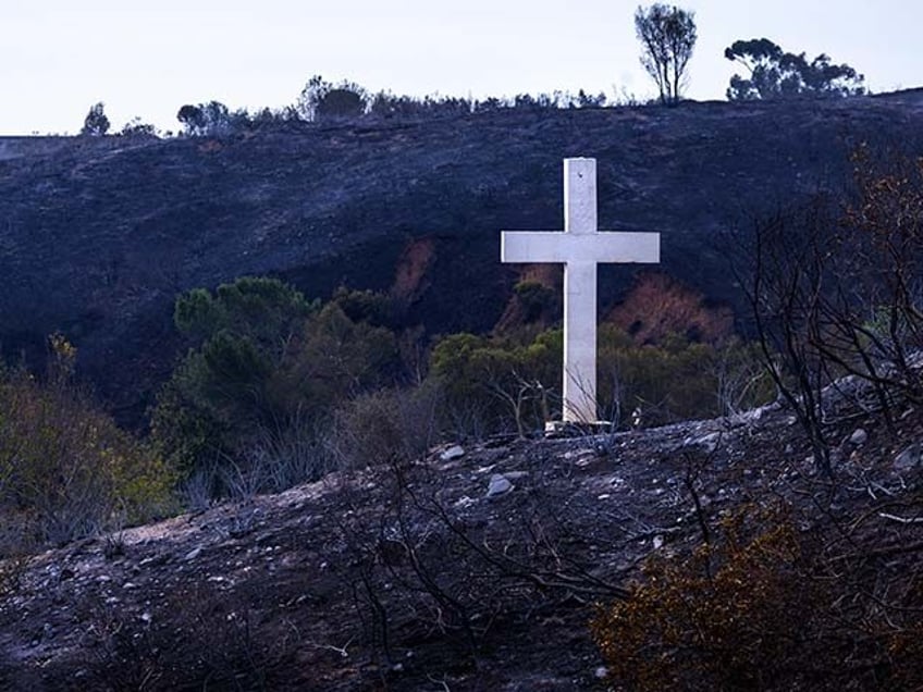 A cross stands amidst brush charred by the Frankiln fire across from Pepperdine University