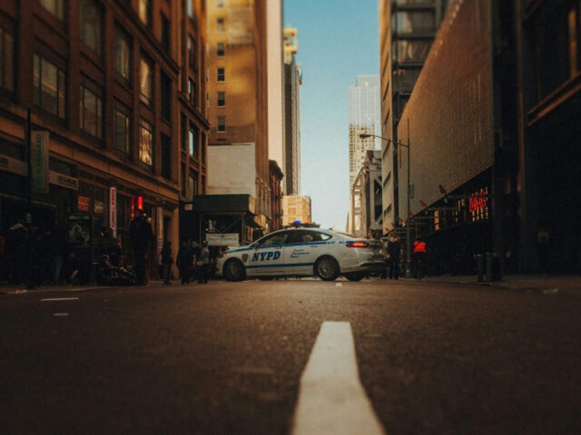 An NYPD car blocks the center of a street (Unsplash/Josh Couch).