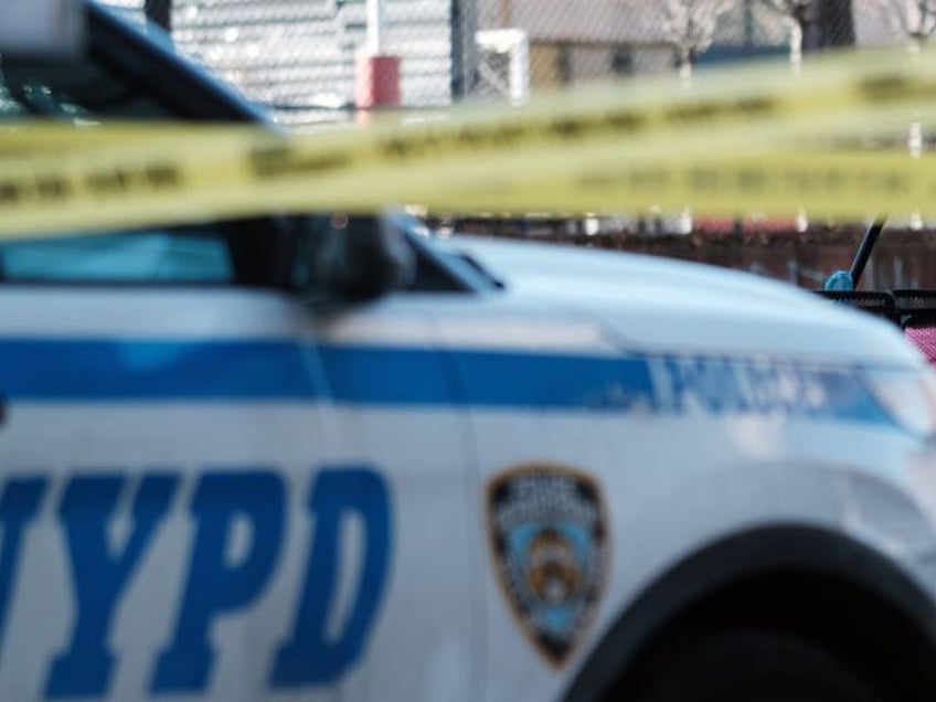 NEW YORK, NEW YORK - JANUARY 22: Residents walk past police vehicles as they gather at the