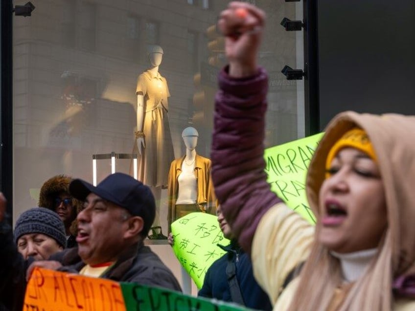 Street vendors, many of them members of the migrant community, participate in a rally and