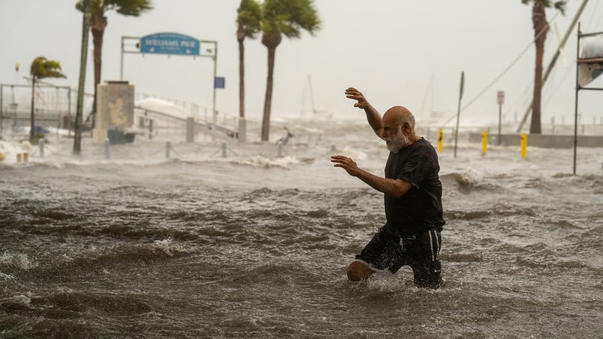 man crosses waters in hurricane helene