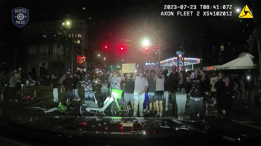 video shows crowd jumping on hood of police vehicle hours before shooting at illegal street race