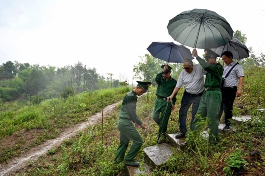 French Dien Bien Phu veteran William Schilardi walks with the help of Vietnamese soldiers