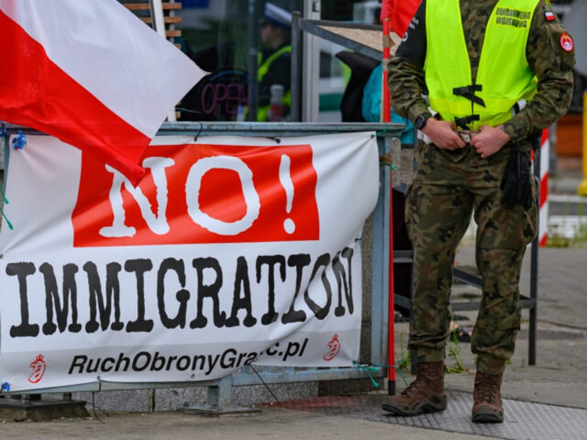 07 July 2025, Poland, Slubice: A Polish military policeman stands next to a banner reading