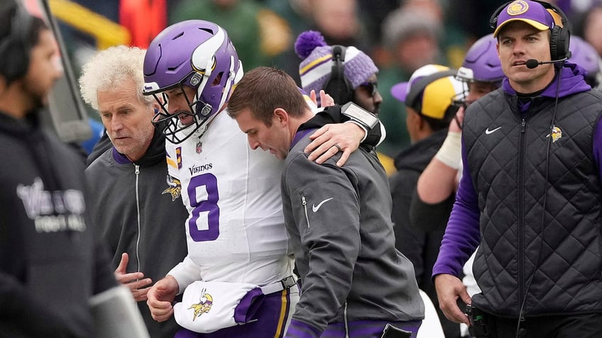 Kirk Cousins is helped off the football field