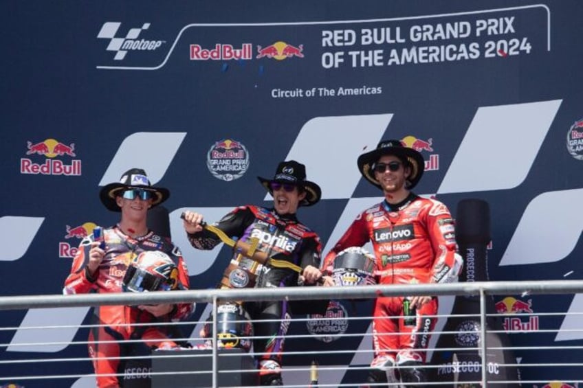 Maverick Vinales of Spain celebrates victory in the MotoGP of the Americas flanked by runn