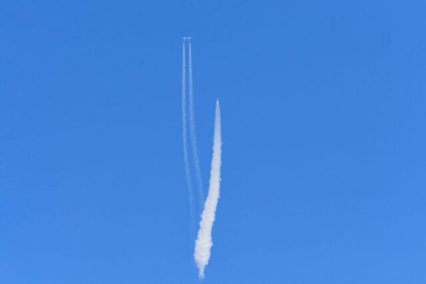 The Virgin Galactic SpaceShipTwo space plane Unity and mothership flies above Spaceport Am