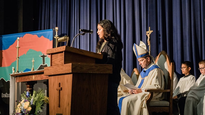 bishop sitting and young girl speaking