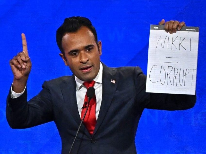 Entrepreneur Vivek Ramaswamy holds up a sign reading "Nikki = corrupt" referring to former Governor from South Carolina and UN ambassador Nikki Haley as he speaks during the fourth Republican presidential primary debate at the University of Alabama in Tuscaloosa, Alabama, on December 6, 2023. (JIM WATSON/AFP via Getty)