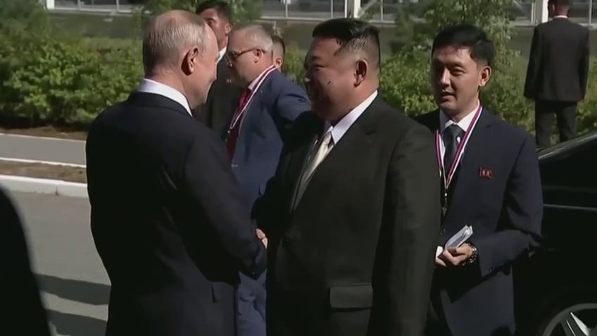 vladimir putin greets north korean leader kim jong un in eastern russia for planned meeting