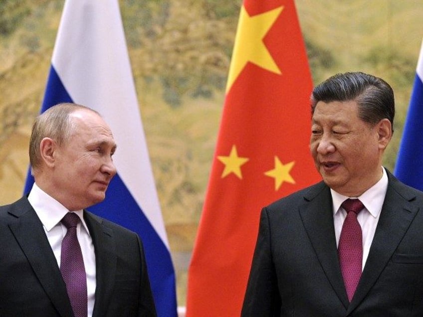 Chinese President Xi Jinping, right, and Russian President Vladimir Putin talk to each oth