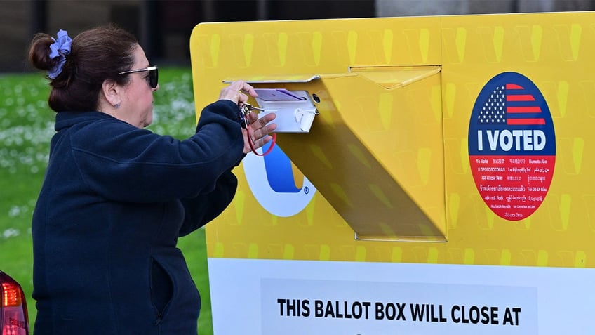 A woman drops off her ballot ahead of the primary election, on March 4, 2024, at the Los Angeles County Registrar in Norwalk, California.  