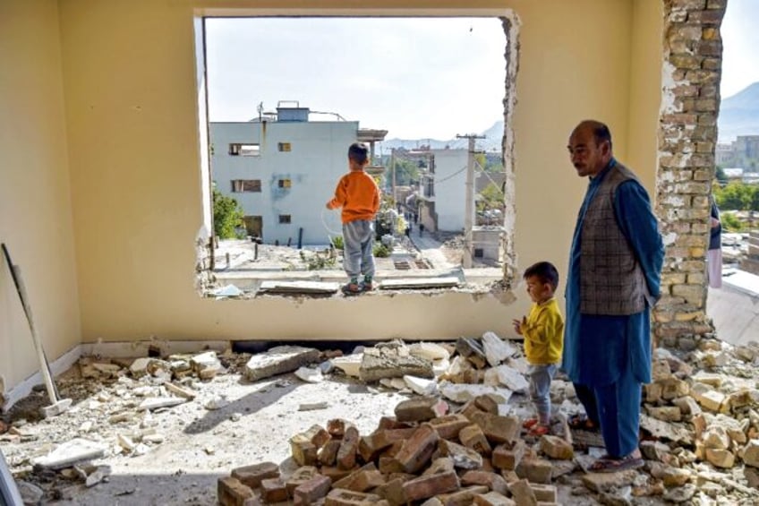 Mohammed Naeem stands with his children amid the rubble of his Kabul home, due for demolit