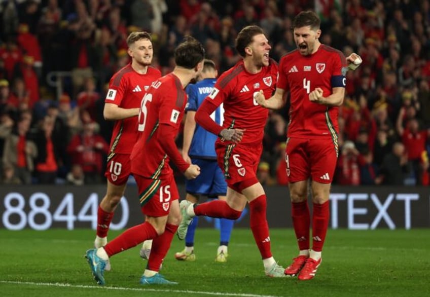 Captain Ben Davies (R) celebrates scoring the second goal for Wales in their 3-1 win over