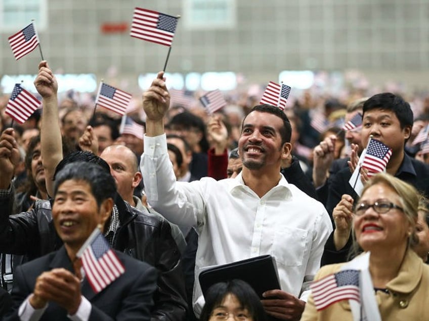 LOS ANGELES, CA - MARCH 20: New U.S. citizens wave American flags at a naturalization cere