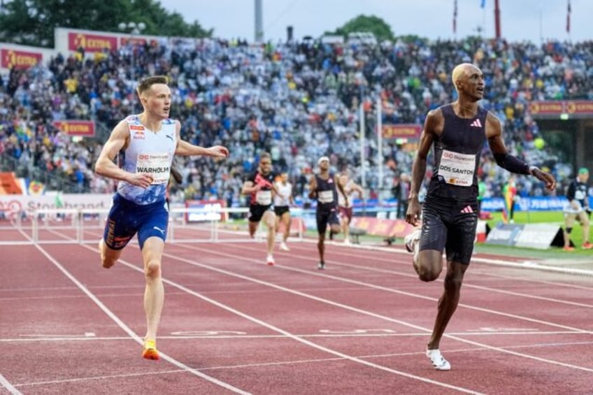 Norway's Karsten Warholm and Alison Dos Santos from Brazil react after the men's 400m hurd