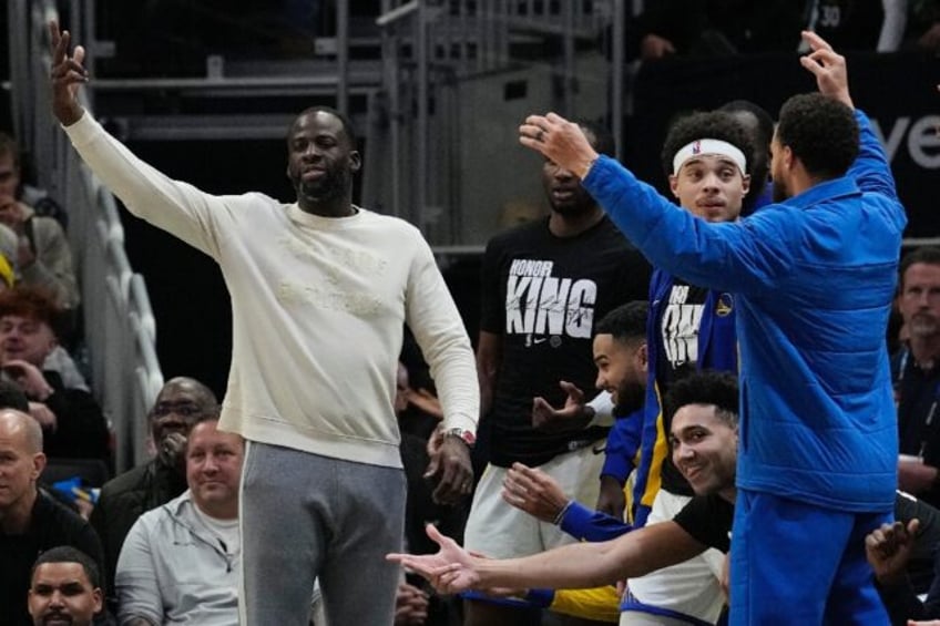 Golden State's Draymond Green reacts with teammates as he watches the Warriors' loss to Milwaukee in preparation for his return from an NBA suspension