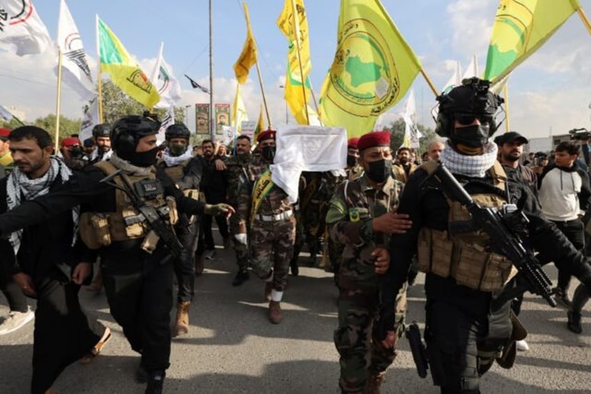 Hundreds of people waving the flags of pro-Iran groups attend the funeral on January 25, 2024 of a fighter killed in US strikes