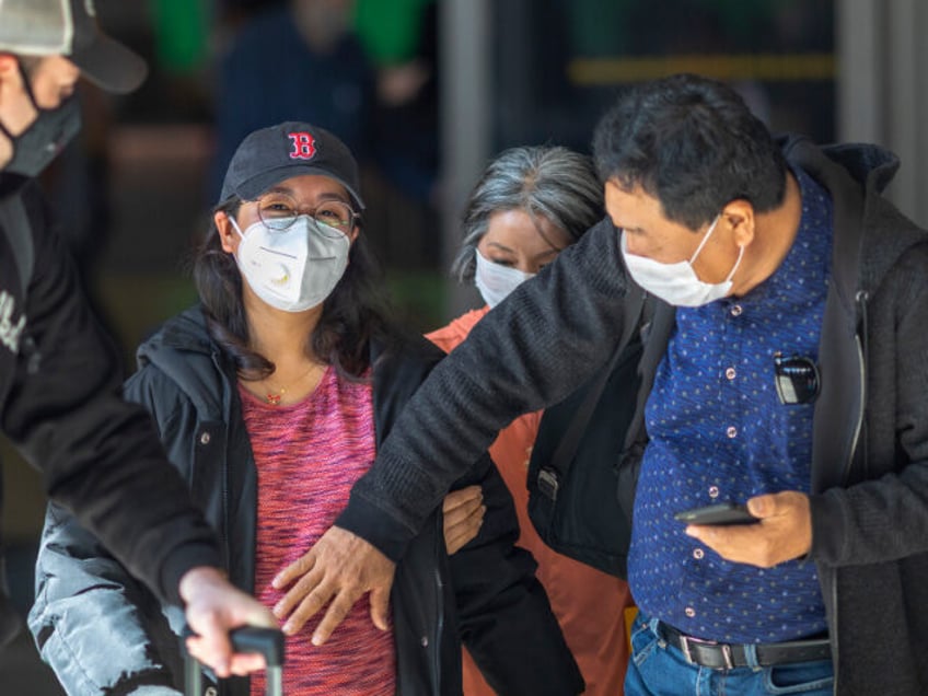 A pregnant woman arrives to LAX Tom Bradley International Terminal wearing a medical mask