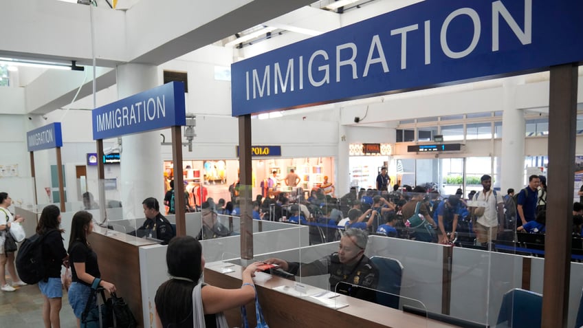 Officers check passports of passengers