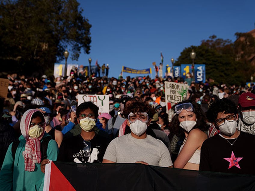 Pro-Palestinian protestors stand on stairs near an encampment at the University of Califor