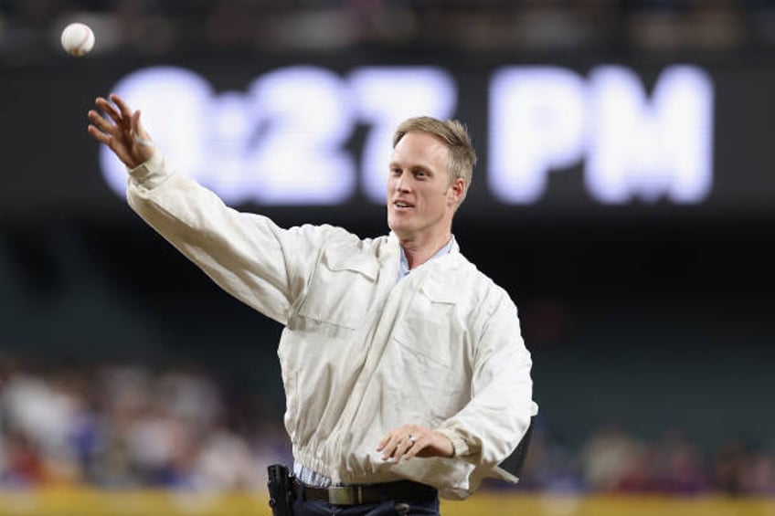 Beekeeper Matt Hilton throws out the ceremonial first pitch during a delay to the MLB game between the Los Angeles Dodgers and the Arizona...
