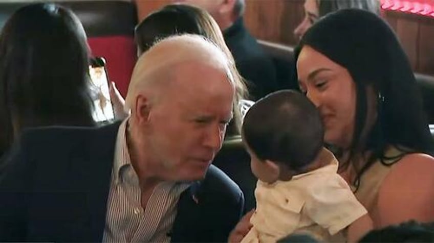watch biden bizarrely wanders off stage mid event to pull faces at a baby