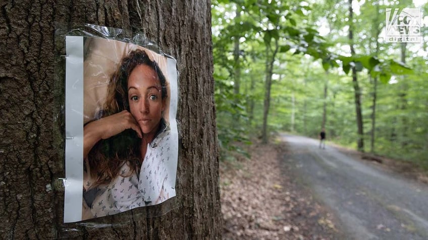 A photo of Rachel Morin is posted on a tree along a hiking route