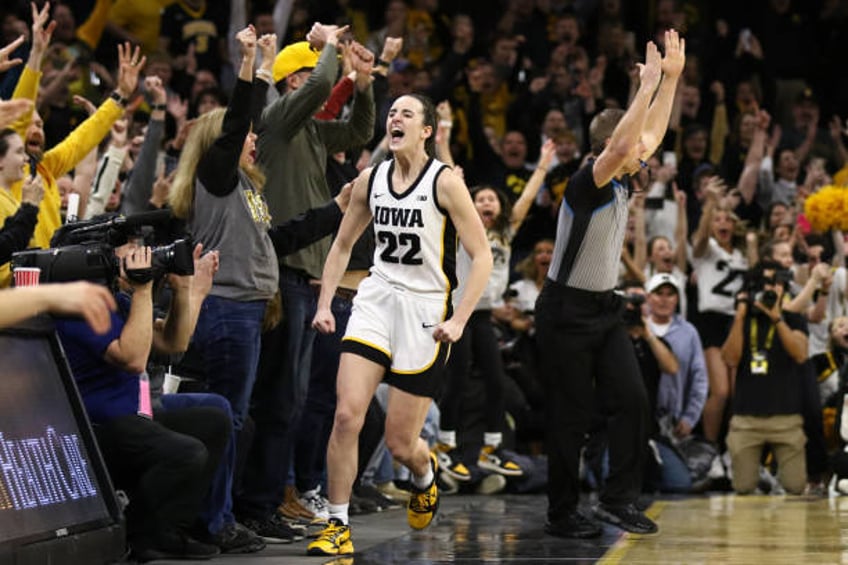 Caitlin Clark of the Iowa Hawkeyes celebrates after breaking the NCAA women's all-time scoring record during the first half against the Michigan...