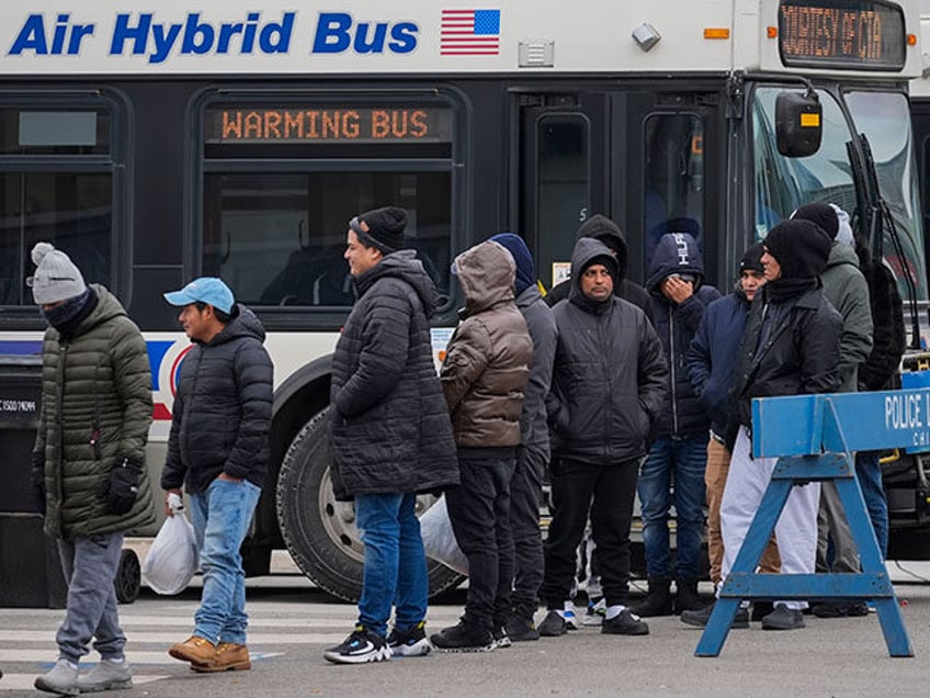 Migrants stand in line to receive food from the nonprofit Chi-Care Thursday, Jan. 11, 2024