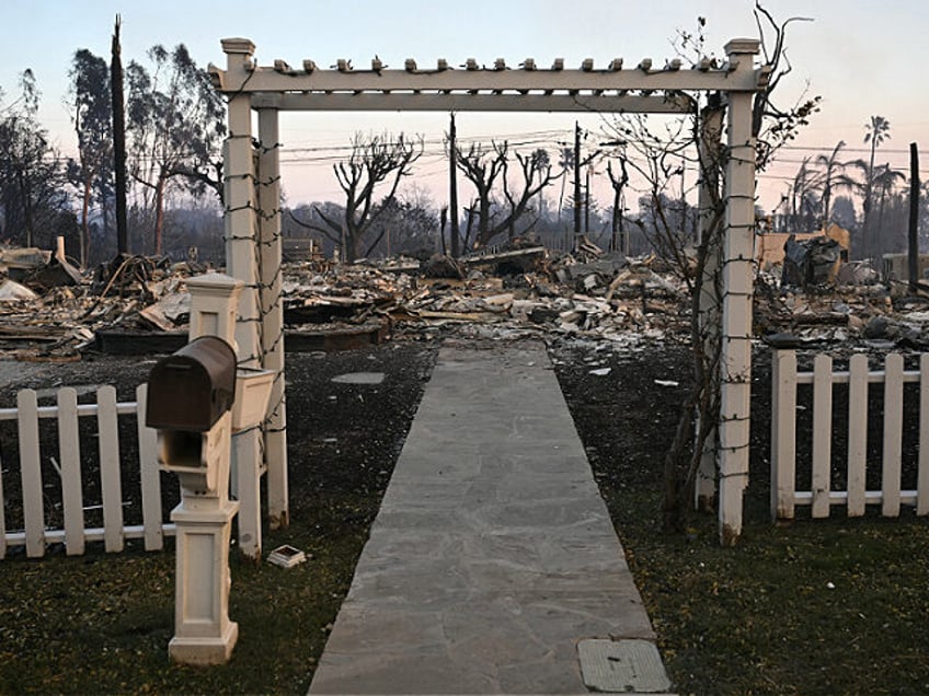 A fence stands intact outside a home destroyed during the Palisades Fire in Pacific Palisa