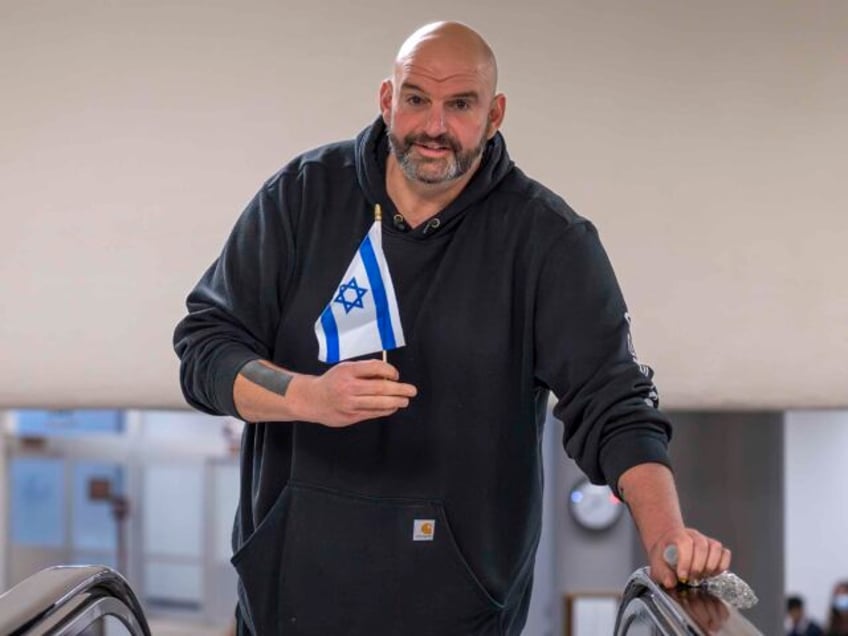 Sen. John Fetterman, D-Pa., holds a small Israel flag as he heads to the chamber for a vote, at the Capitol in Washington, Thursday, Jan. 25, 2024. (AP Photo/J. Scott Applewhite)
