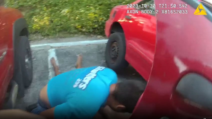 watch florida police officers lift car off man trapped underneath somebody pull him out