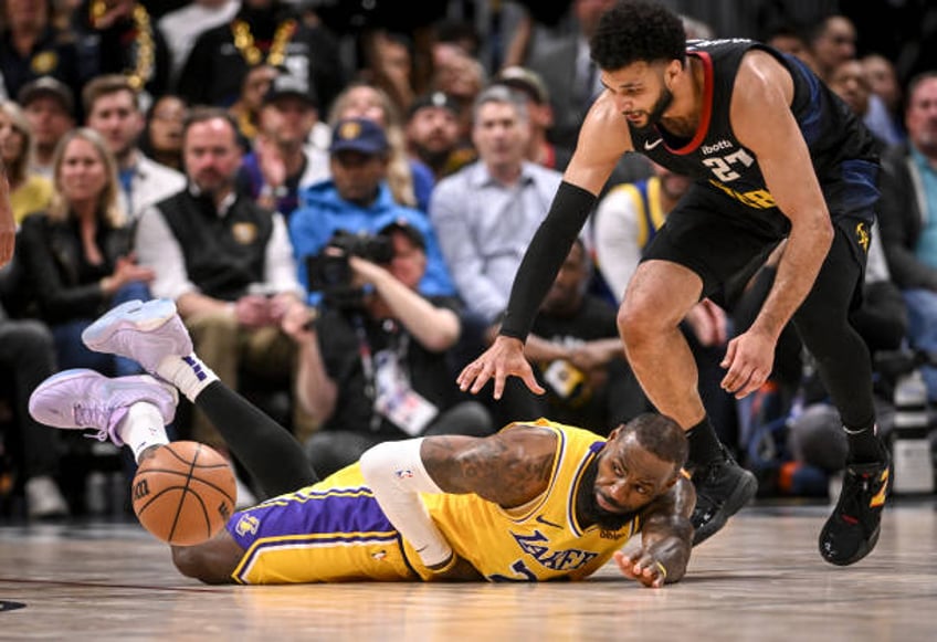 LeBron James of the Los Angeles Lakers loses the ball as he falls to the ground as a hungry Jamal Murray of the Denver Nuggets pounces during the...