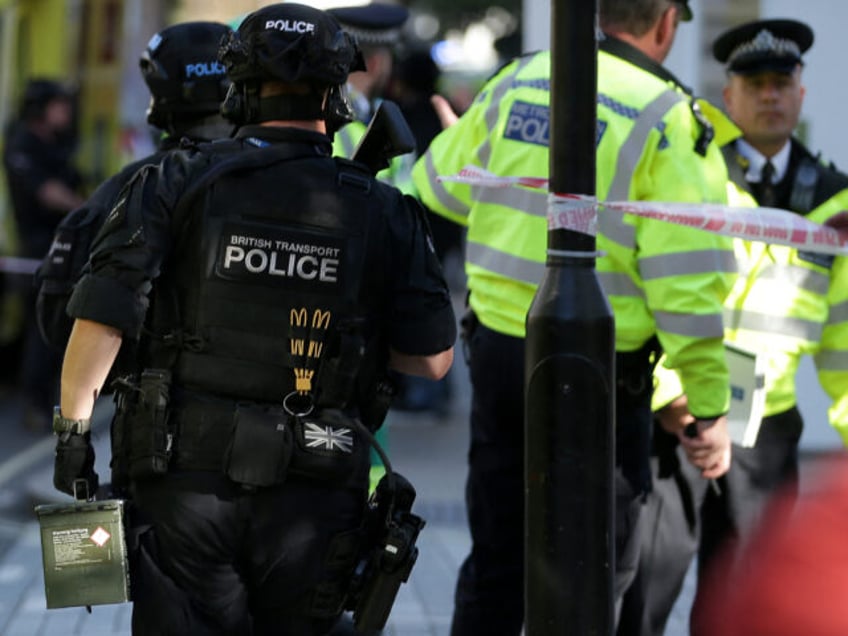 Armed British police officers stand on duty outside Parsons Green underground tube station