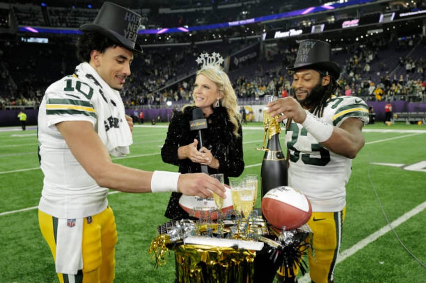 Jordan Love and Aaron Jones of the Green Bay Packers celebrate after a 33-10 victory against the Minnesota Vikings at U.S. Bank Stadium on December...