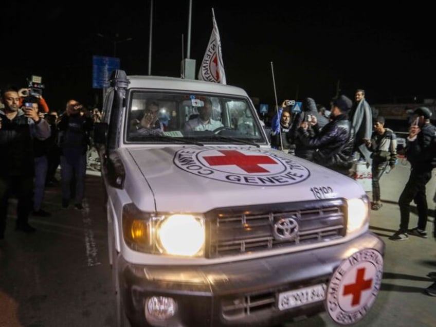 watch palestinians in gaza city taunt red cross van carrying israeli hostages