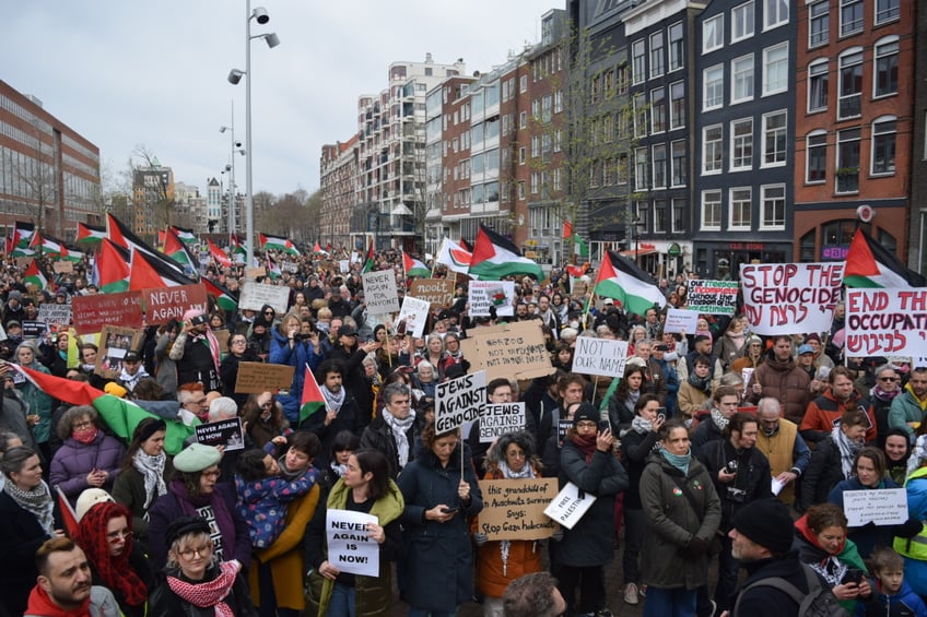 AMSTERDAM, NETHERLANDS - MARCH 10: People stage a pro-Palestinian demonstration during the opening of the Holocaust Museum in Amsterdam, Netherlands on March 10, 2024. The Jewish community demanded the arrest of Israeli President Isaac Herzog, whom they described as a war criminal. They called for his immediate arrest by the International Court of Justice in The Hague instead of inviting him to attend alongside the king. Protesters gathered outside the museum while the king and President Isaac Herzog were inside, celebrating the inauguration with the presence of former Dutch Prime Minister Mark Rutte. The protest, held near the museum at Waterlooplein market, witnessed heavy security presence amid widespread public anger demanding an end to what the protesters described as a travesty. (Photo by Mouneb Taim/Anadolu via Getty Images)