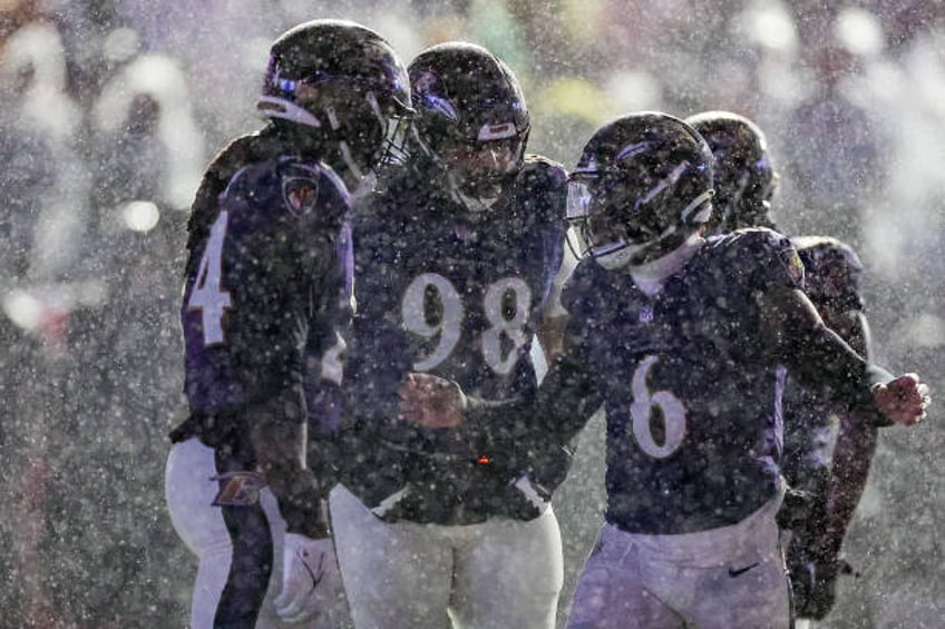 Patrick Queen of the Baltimore Ravens talks with Jadeveon Clowney during a timeout in the fourth quarter of a game against the Pittsburgh Steelers at...