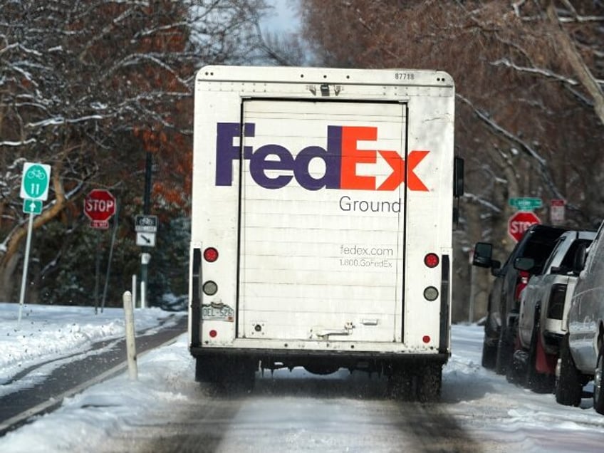 A FedEx delivery van moves along Marion Parkway as a winter storm sweeps over the intermou